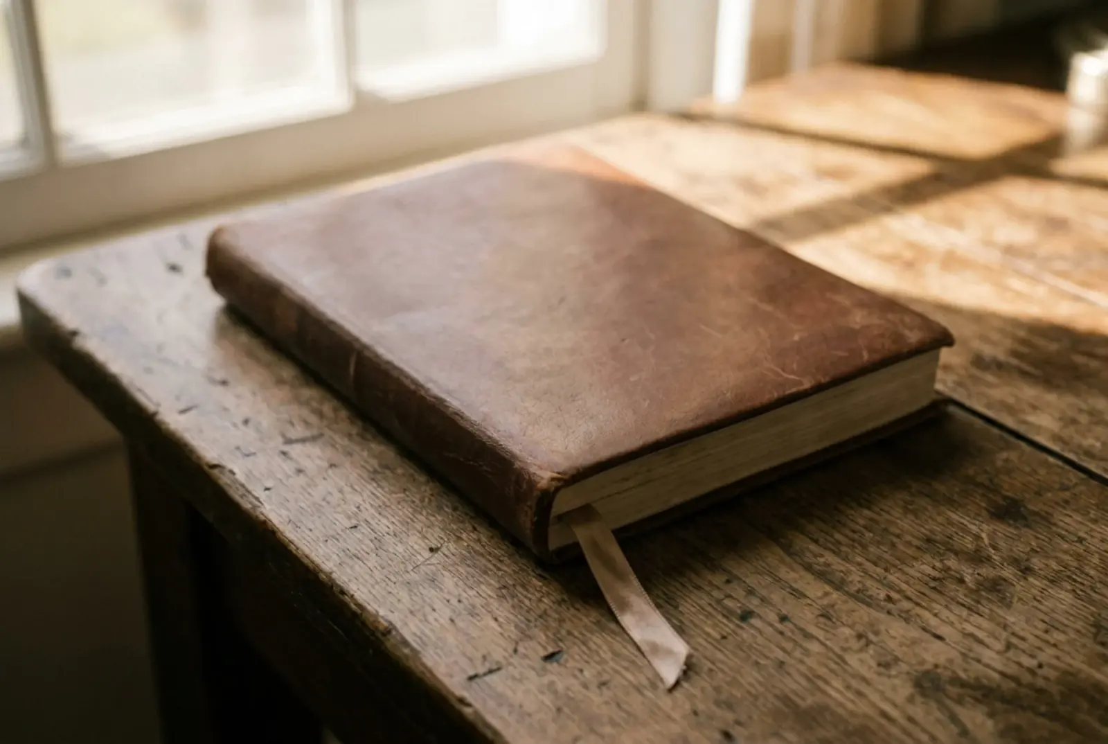 An open hardcover memoir on a quiet desk with a marked-up manuscript, a fountain pen, and an annotated reading list — what a memoir is, in working form.